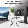 USB-C to DisplayPort cable connected from a USB-C laptop to a DisplayPort monitor in an office setup