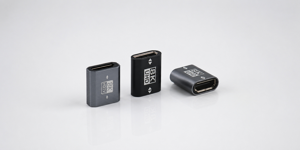 Three 8K HDMI female-to-female adapters in black and gray on a light gray background